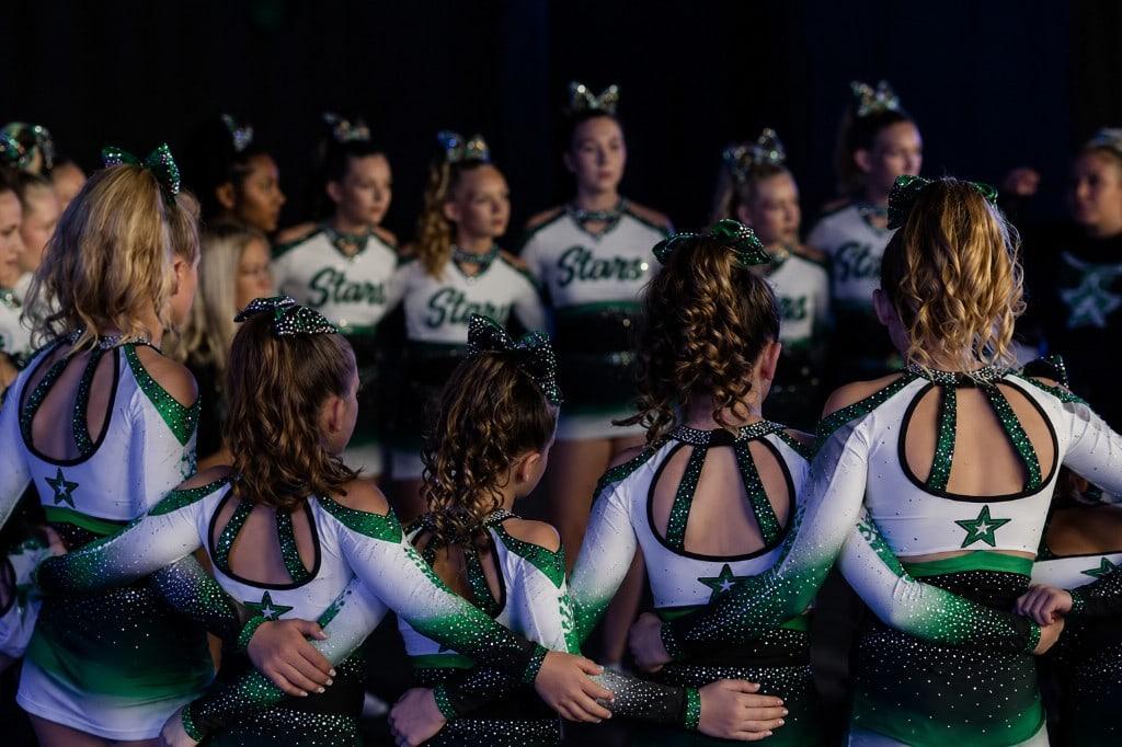 Allstar athletes in green and white uniforms standing together before a performance